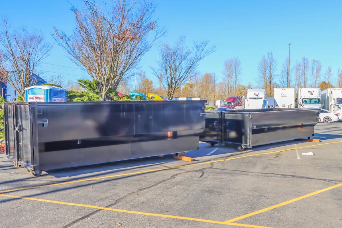 Professional dumpster rental service with roll-off container on residential driveway in Rindge